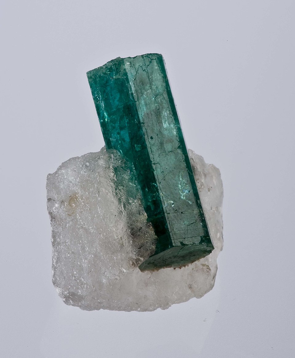 An emerald crystal set in quartz, shown as a gemstone reference
