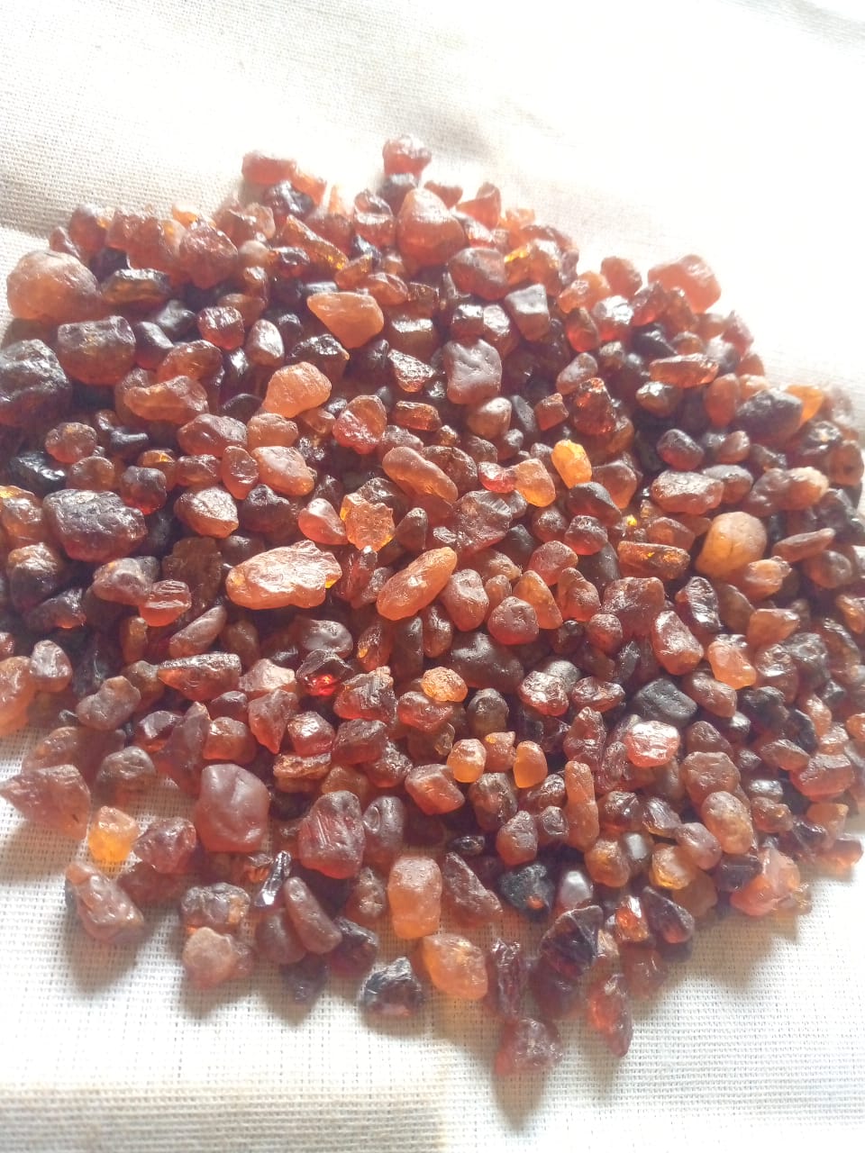 Orange rough stones displayed on a light fabric